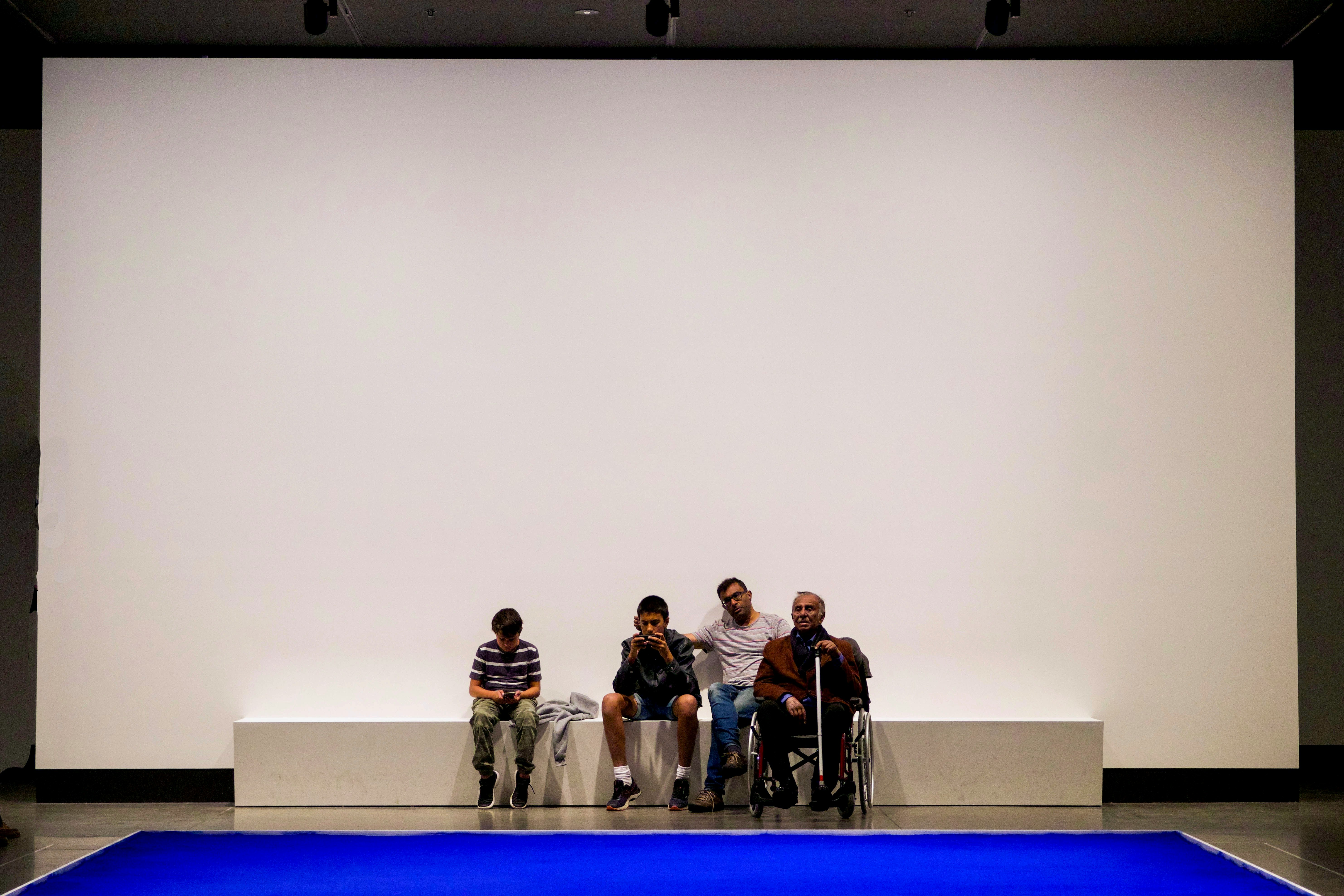 group of people sitting on blue bench